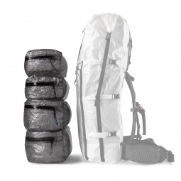 Vier Hyperlite Mountain Gear Pods 4400 beispielhaft übereinander gestapelt mit passendem Rucksack daneben