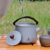 Titanium 240 ml Pour Over Tea Pot draußen auf einem Tisch platziert, während Wasser hineingegossen wird