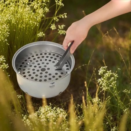 Beim Keith Titanium Portable Grill kann die separat erhältliche Titanzange von Keith helfen, das Ascheblech herauszunehmen