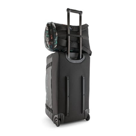 Patagonia Black Hole Pack 25L Tagesrucksack Kalaido Black über Rollgepäck geschoben