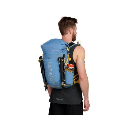 Ultimate Direction Fastpack 30 Rucksack beispielhaft am Rücken getragen mit befestigten Stöcken