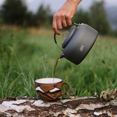 aus dem Esbit Aluminium Kessel wird Kaffee in eine Tasse gegossen