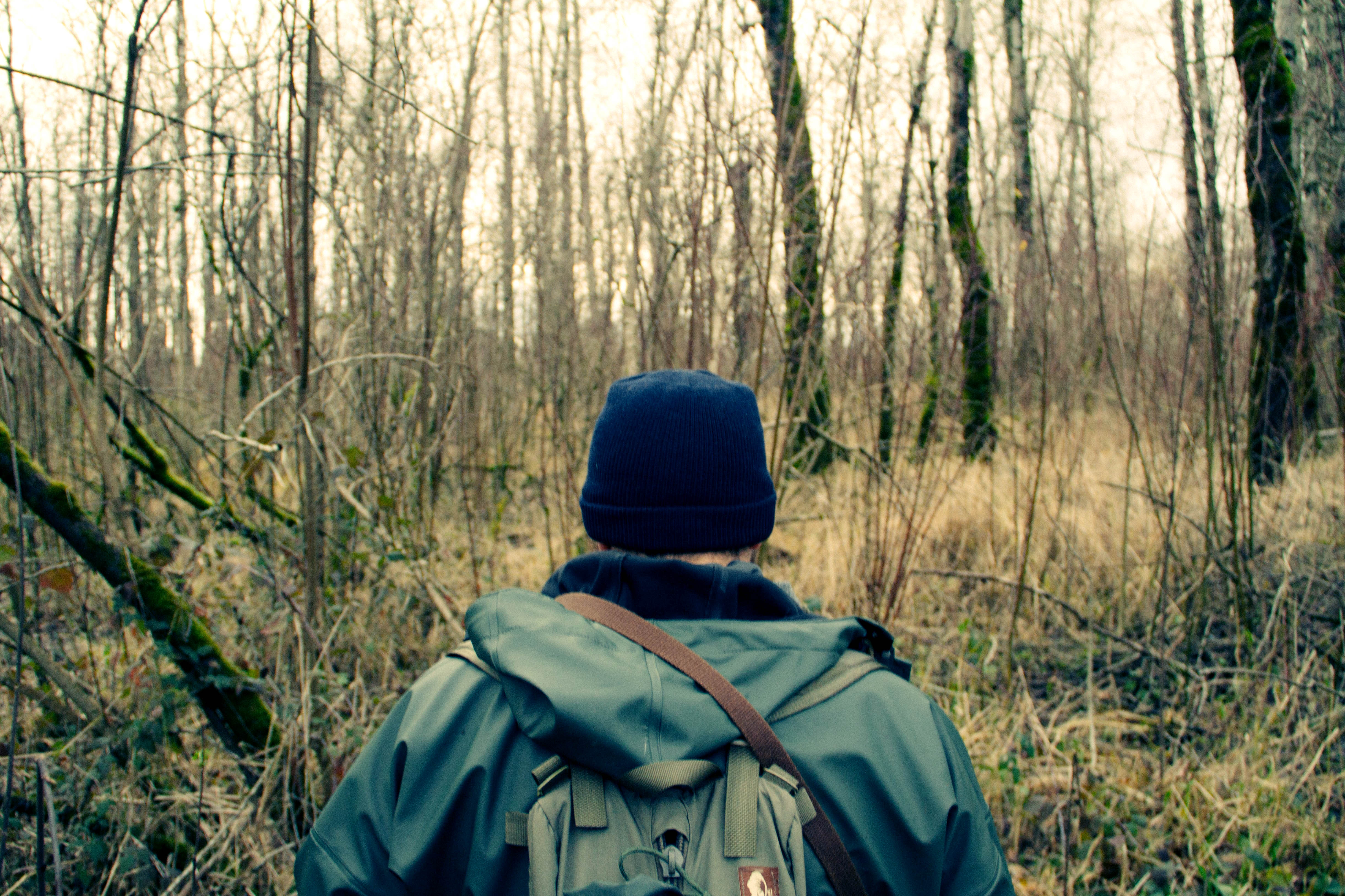 Mann mit Fluchtrucksack im Wald unterwegs